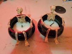 two skeleton figurines sitting on top of a table