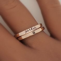 a person's hand with a ring that says parker on it and a paw print