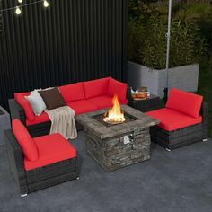 an outdoor fire pit surrounded by furniture and lights