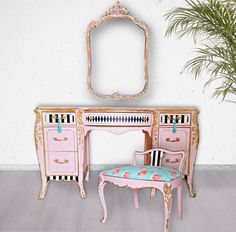 a pink dressing table with mirror and chair