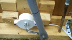 a white toilet sitting on top of a pile of wooden blocks next to a metal pole