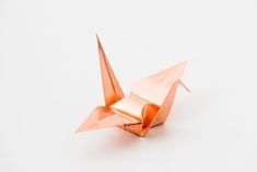 an orange origami bird on a white background