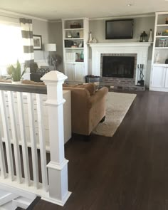 a living room filled with furniture and a flat screen tv mounted on the wall above a fireplace