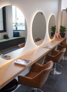 a row of chairs sitting next to each other in front of a table with mirrors on it