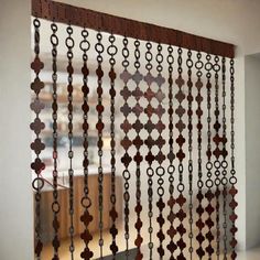 a metal curtain with circles and chains hanging from it's side in front of a window