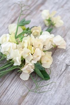 some white flowers sitting on top of a wooden table