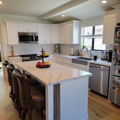 a kitchen with white cabinets and stainless steel appliances