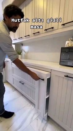 a man standing in front of a white kitchen counter top with the words mutak altti gizit masa on it