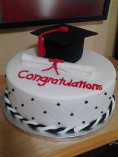 a graduation cake with congratulations written on it and a mortar cap sitting on top of the cake