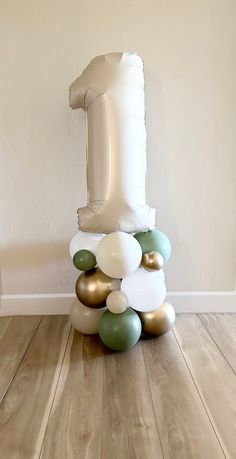 an inflatable number one balloon sitting on top of a wooden floor next to a wall