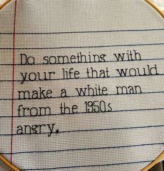 a close up of a cross stitch on a piece of paper with words written in it