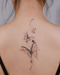 the back of a woman's neck with a butterfly tattoo on it