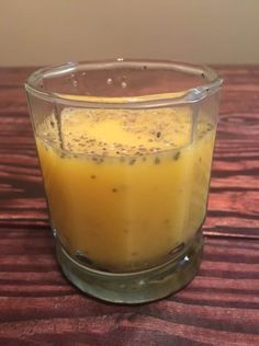 a glass filled with liquid sitting on top of a wooden table