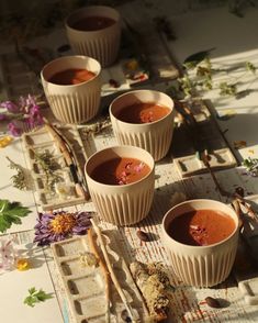 four cups filled with soup sitting on top of a table