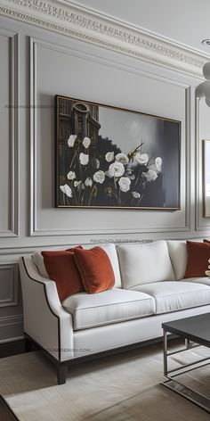 a living room with white couches and paintings on the wall