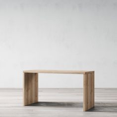 a wooden table sitting on top of a hard wood floor next to a white wall