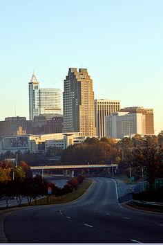 the city skyline is shown with tall buildings in the foreground and an empty road on the other side