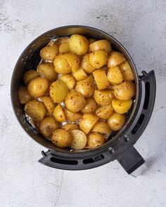 a pot filled with potatoes sitting on top of a table