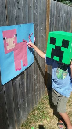 a young boy is holding up a paper block shaped like an animal with scissors in his hand