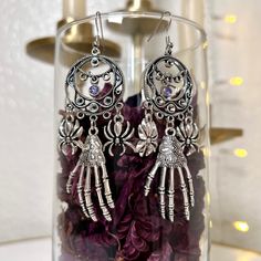 These handmade skeleton hand dangle earrings make a perfect addition to any jewelry collection. Whether for Halloween or simply everyday wear, these earrings add a fun and spooky touch to any look. No matter the occasion, they're sure to make a wonderful gift to any horror-loving loved one or even yourself. - 9cm x 4cm - 22 gauge - Handmade - Zinc alloy, silver-toned iron alloy, and rhinestones - Lead-free and nickel-free Skeleton Hand, Skeleton Hands, Dangle Charms, Charm Earrings, Jewelry Earrings Dangle, Etsy App, Selling On Etsy, Sell On Etsy, Etsy Earrings