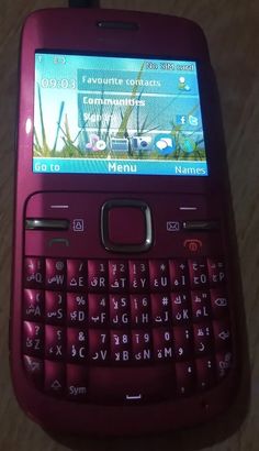 a purple cell phone sitting on top of a wooden table