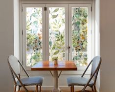 two chairs sitting at a table in front of a window