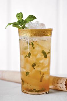 a tall glass filled with ice and mint