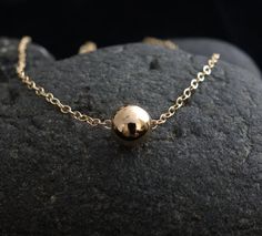 A shining, large gold filled bead floats on a rich gold filled necklace.The ultimate in simplicity, this gorgeous necklace is perfect for everyday, and even your most special nights.The 7mm shining bead is gold filled/ sterling silver, chain and spring clasps are gold filled/sterling silver.I also have an Matte Agate Stone Bead Necklace in Sterling Silver:https://www.etsy.com/listing/87166685/matte-agate-stone-bead-necklace-in?ref=shop_home_active_1&ga_search_query=beadYour item comes wonder Stone Bead Necklace, Round Bead Necklace, Gold Filled Necklace, Single Bead, Stone Beaded Necklace, Silver Bead, Gold Filled Jewelry, Gorgeous Necklaces, Agate Stone