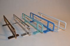 three metal racks with handles and bars on each side, one is blue and the other is silver