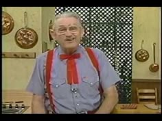 an old man with glasses and a red bow tie standing in front of a kitchen