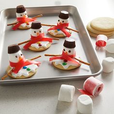 some marshmallows are sitting on a cookie sheet with snowmen made out of them