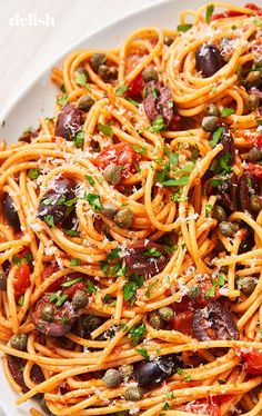 a white plate topped with spaghetti and olives