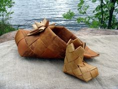 a pair of shoes made out of woven material sitting on top of a rock next to the water