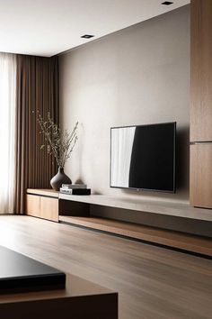 a living room with a large flat screen tv on the wall and wooden flooring