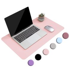 an open laptop computer sitting on top of a pink mouse pad next to a keyboard