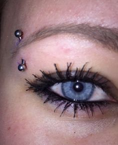 an eye with some piercings on it