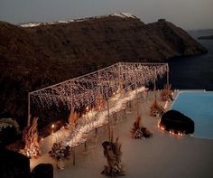 an aerial view of a table set up with candles and flowers next to the pool