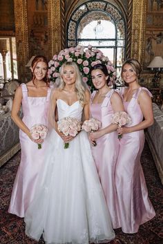 four bridesmaids in pink dresses posing for the camera