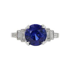 a blue sapphire and diamond ring with baguetts on the sides, set in white gold