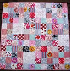 a patchwork quilt on a wooden bench