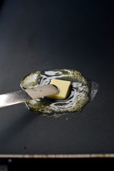 a spatula being used to spread cheese on top of some kind of food in a pan