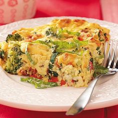 a slice of quiche with broccoli and other vegetables on a white plate