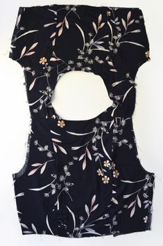 a piece of black fabric with flowers and leaves on it, cut in half to make a square shape