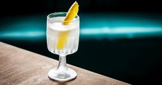 a close up of a glass on a table with a slice of lemon in it