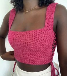 a woman wearing a pink crochet crop top