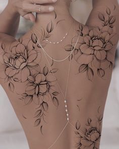 the back of a woman's body with flowers on it