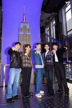 four young men posing in front of the empire building