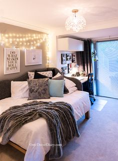 a bedroom with a large bed and lights on the wall