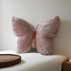 a pink butterfly pillow sitting on top of a bed