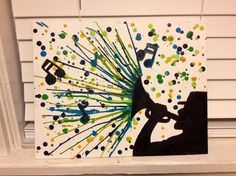 a painting with music notes on it and paint splatters all over the frame